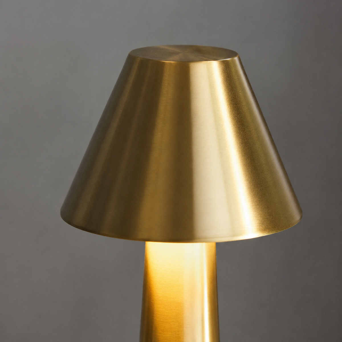 Close-up of the brushed gold conical shade with warm LED glow