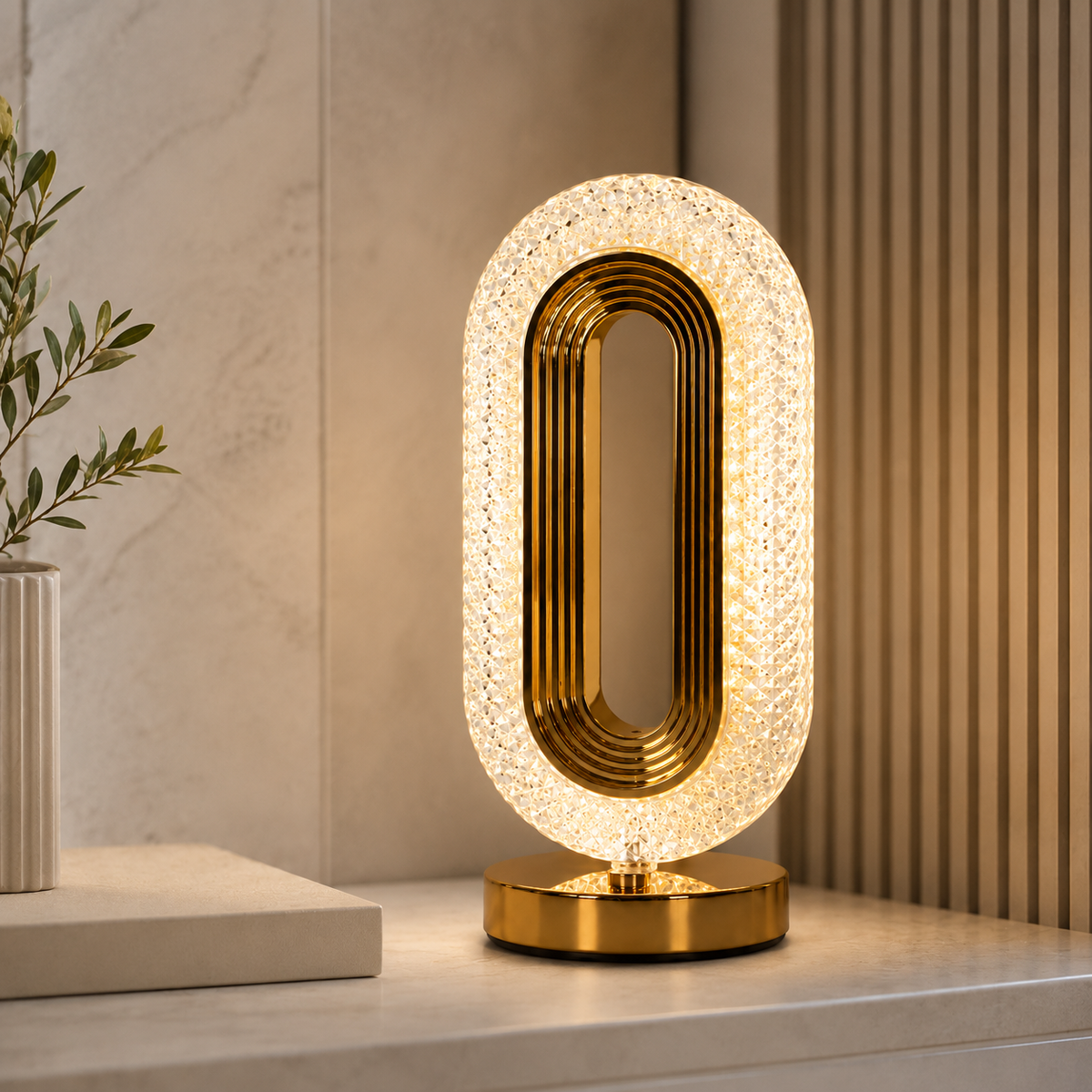 Oval crystal table lamp with gold base on a white console table